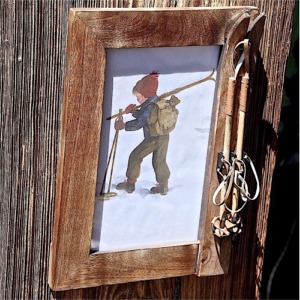 Kleiner Fotorahmen aus verbranntem Holz mit Ski und Stöcken rechts